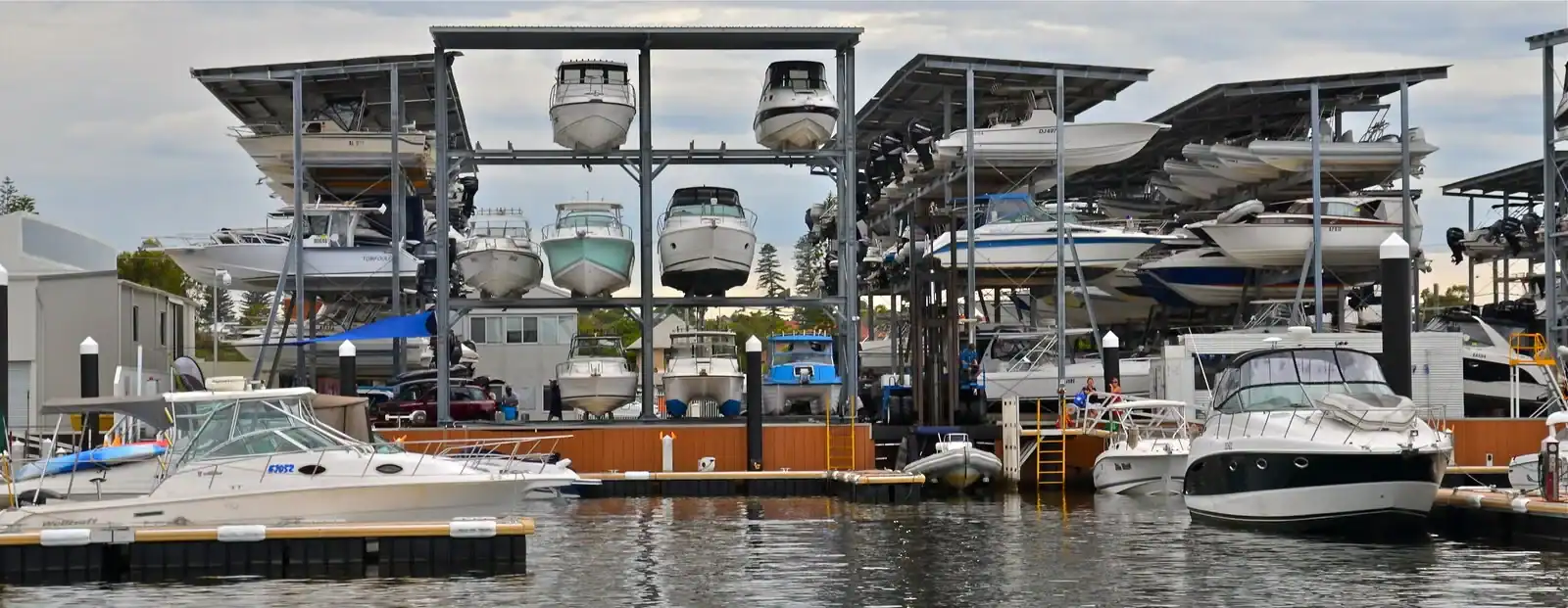 Motorboats on roof-covered, open-sided storage racks beside a marina in Fremantle, Western Australia.